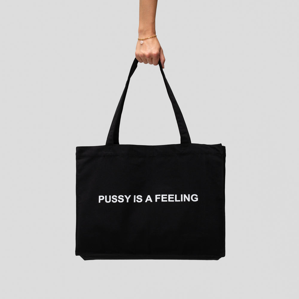 Big black bag with white PUSSY IS A FEELING print designed by Identities Brand.
