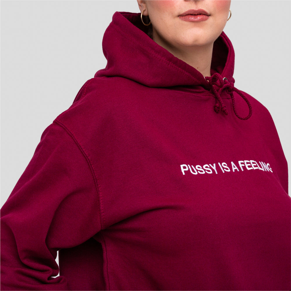 Burgundy hoodie with white PUSSY IS A FEELING embroidery designed by Identities Brand.