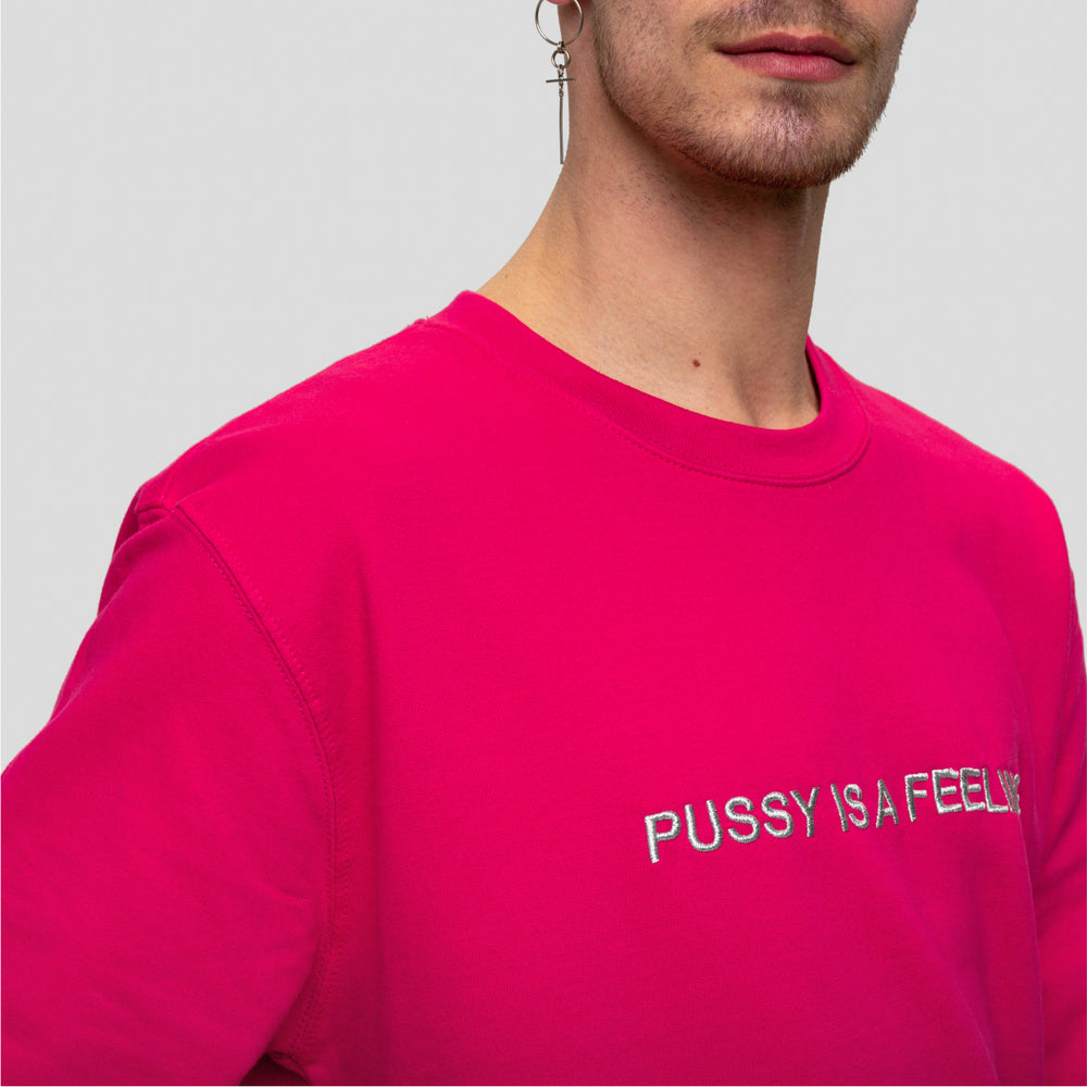 Hot pink crewneck sweater with silver PUSSY IS A FEELING embroidery designed by Identities Brand.